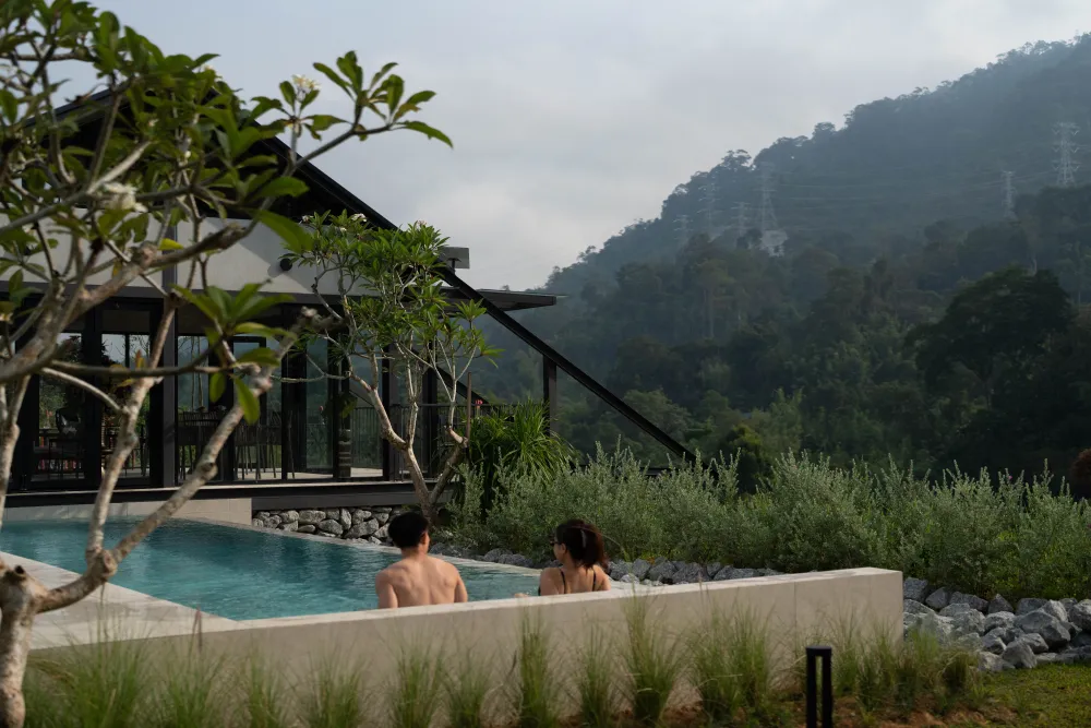 Guests relaxing in the pool with mountain views